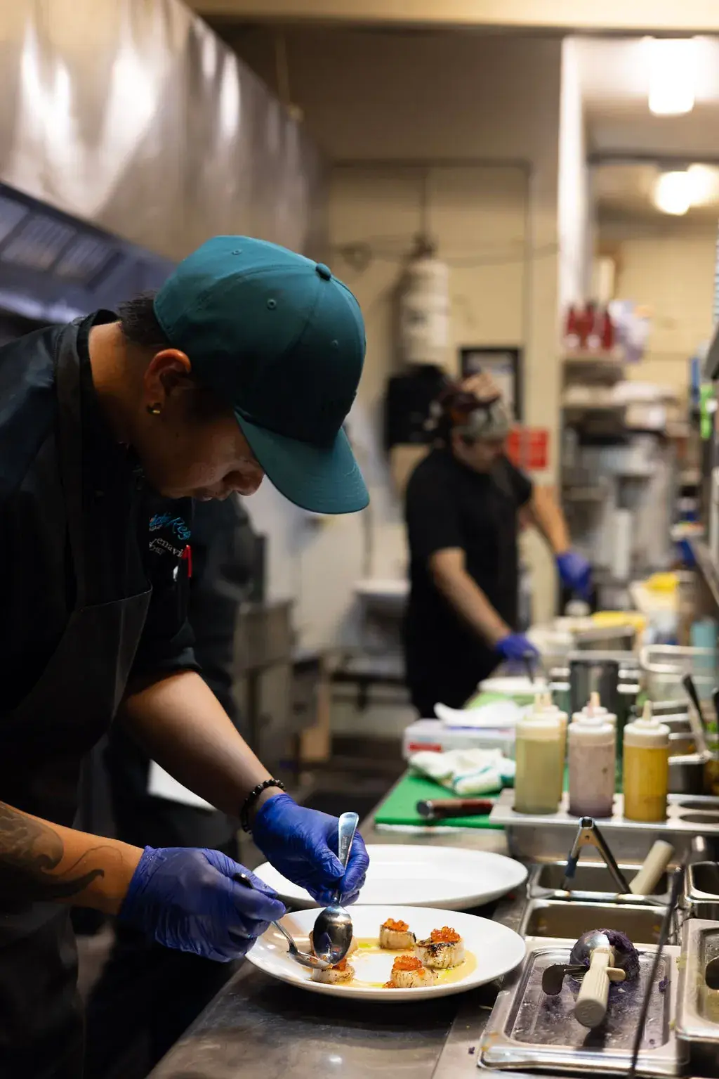 A Jackie Rey's chef plating seared scallops in the Kona kitchen.