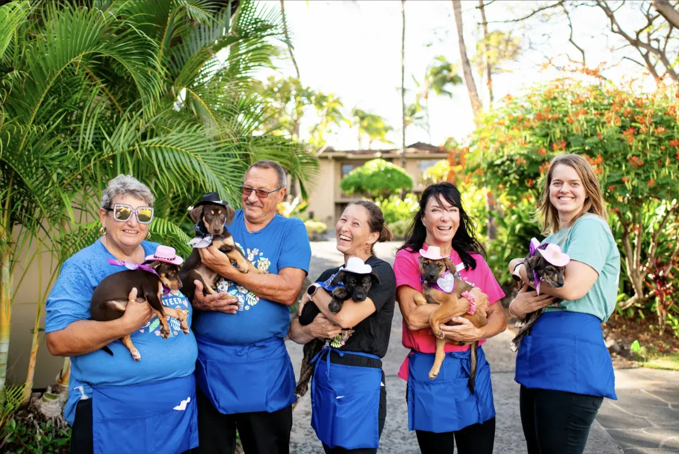 Hawaii Island Humane Society volunteers holding rescue puppies outside in Kona.
