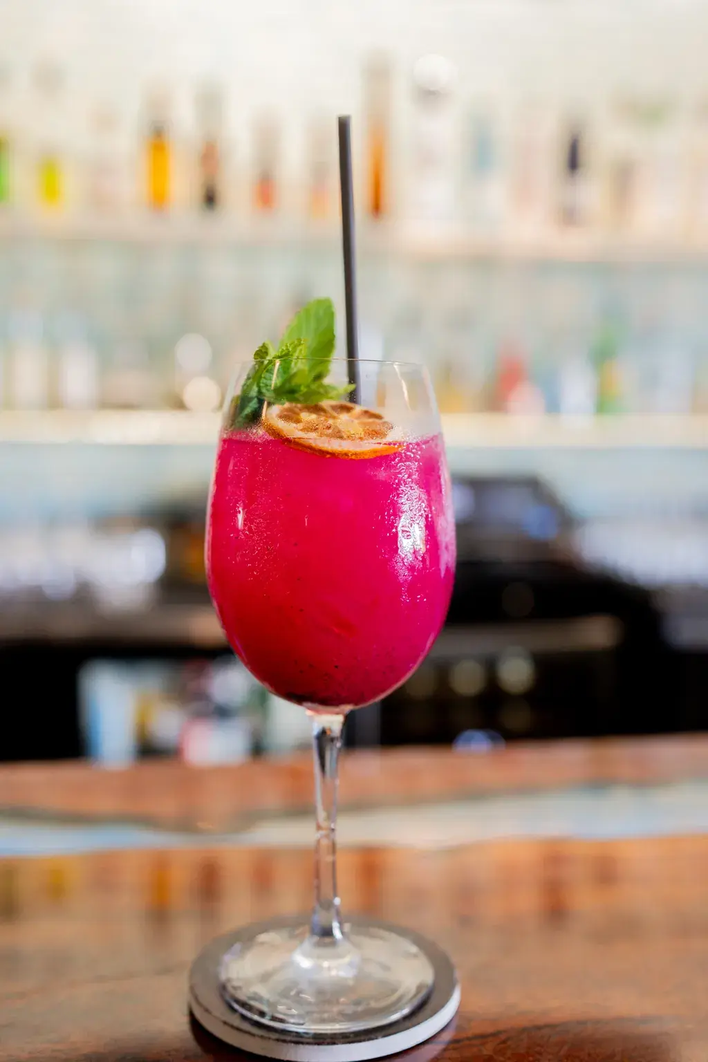 Dragon fruit cocktail garnished with mint and dried citrus at Jackie Rey's Kona.