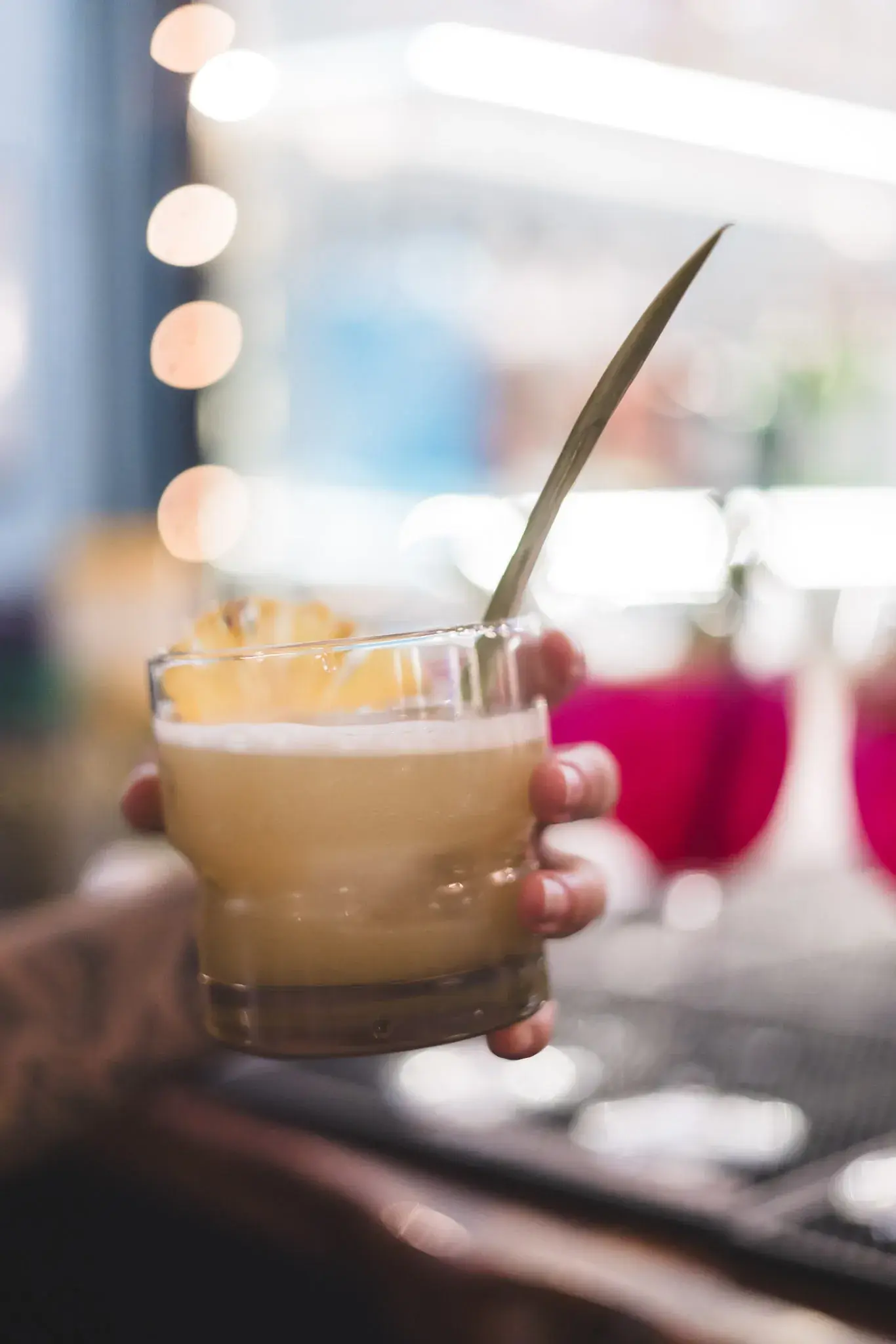 Bright citrus cocktail being poured at Jackie Rey's Kona.
