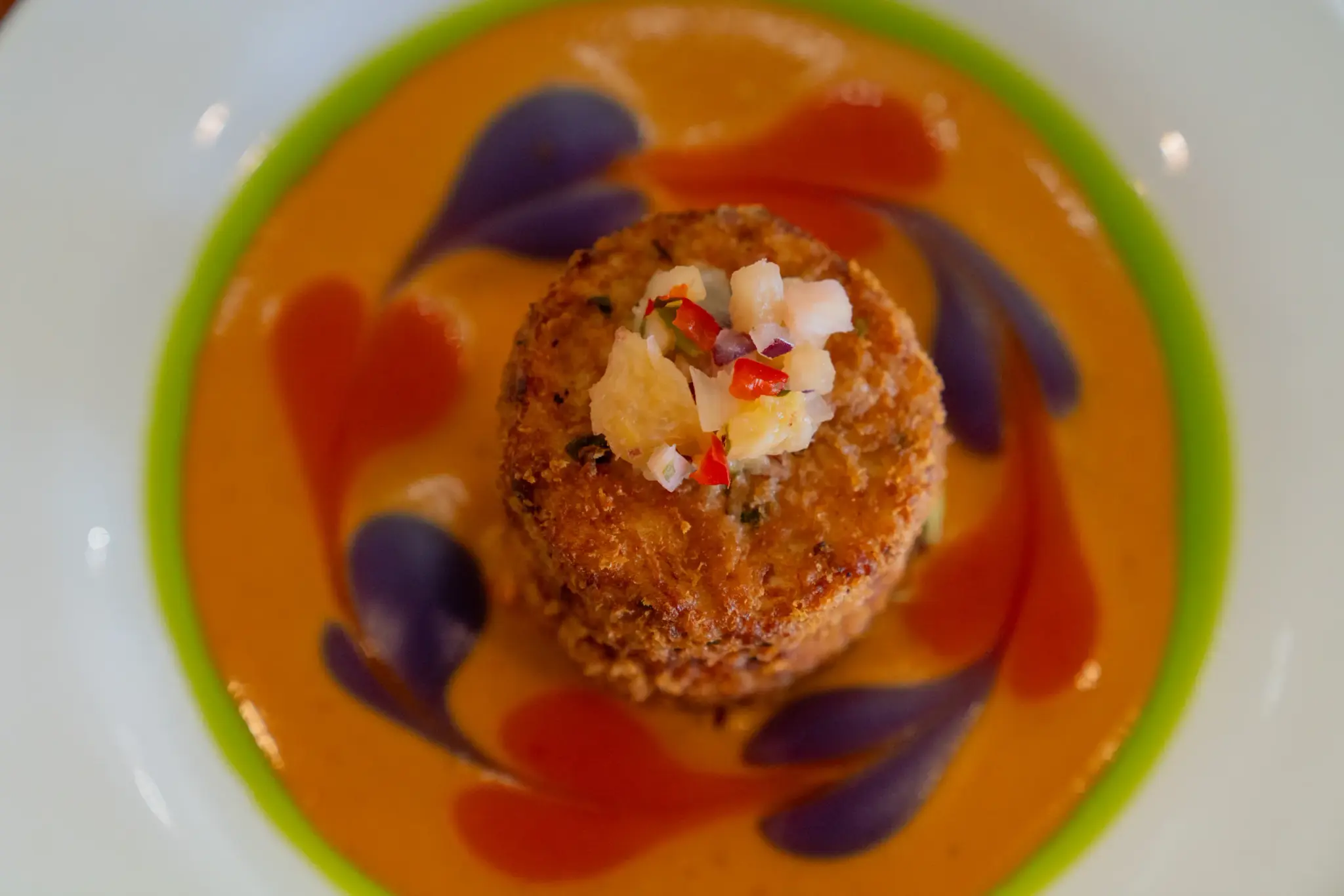 Housemade Crab Cakes at Jackie Rey's Ohana Grill, Red Thai curry, triple chili emulsion, Molokai potato emulsion, pineapple relish.