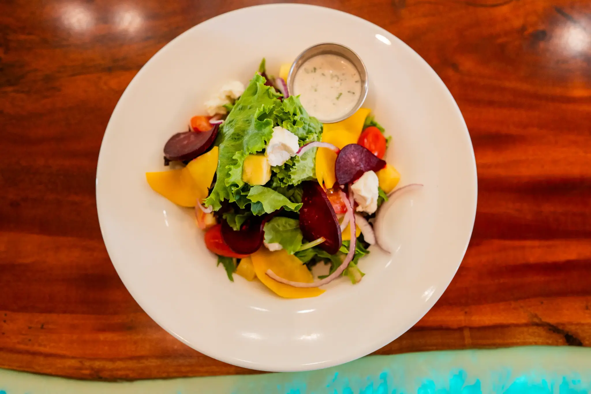 Island Salad at Jackie Rey's Ohana Grill, Mixed greens, beet, seasonal fruit, grape tomato, red onion, feta, lilikoi vinaigrette or coconut ranch.
