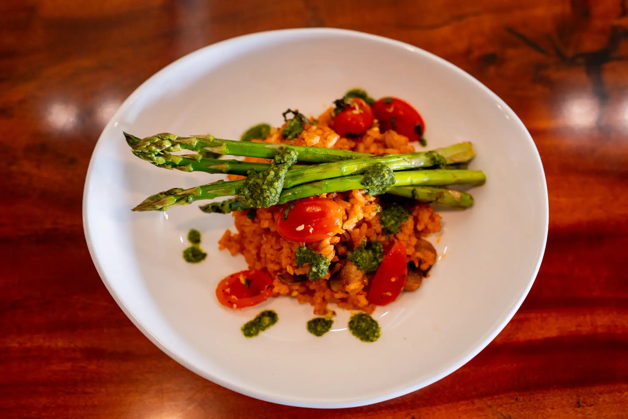 Mushroom Risotto at Jackie Rey's Ohana Grill, Button mushroom, tomato risotto, grilled asparagus, tomato relish, basil pesto.