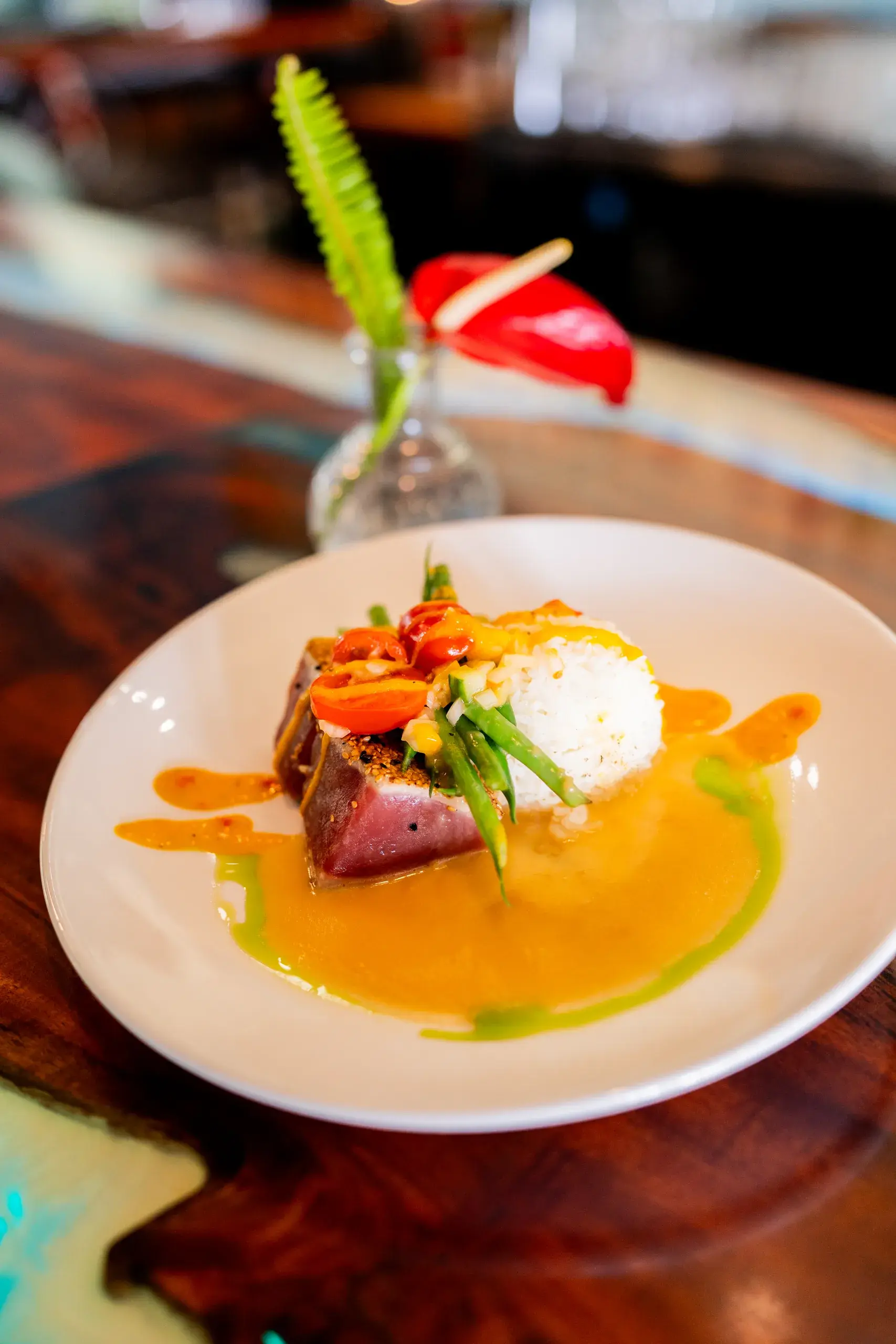 Togarashi Crusted Ahi at Jackie Rey's Ohana Grill, Garlic vegetables, jasmine rice, lilikoi chili sauce, lomi-lomi grape tomato.